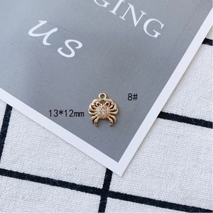 Detail of a 13x12mm gold plated crab pendant with inlaid rhinestones and red gem eyes