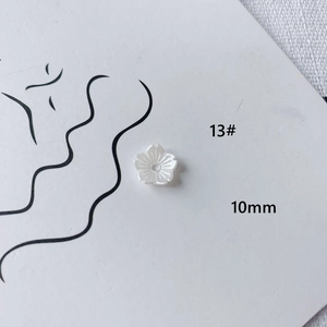 Macro shot of 10mm pearl white acrylic flower charm with detailed petal texture