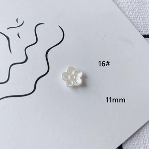 Macro shot of 11mm white acrylic flower charm with pearl luster for DIY jewelry making