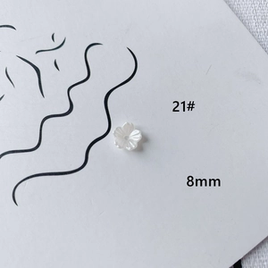 Macro shot of 8mm white acrylic flower beads for DIY jewelry making and nail art