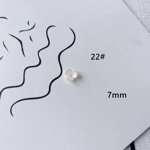 Detailed macro view of a 7mm white acrylic flower bead with delicate textured petals