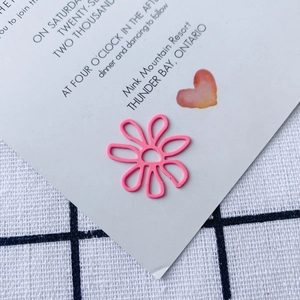 Detail view of a pink matte flower pendant for DIY jewelry on a white card background