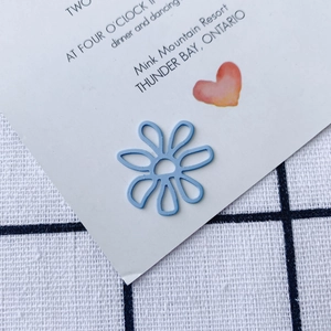 Close-up of light blue hollow metal flower charm for DIY jewelry and accessories