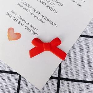 Macro-detail van een matte rode hars strik oorbel component met realistische textuur