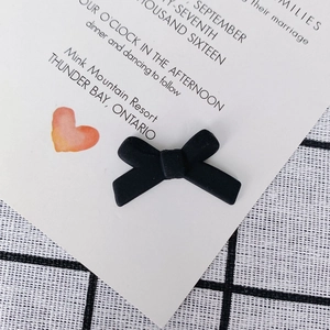 Macro-opname van matzwarte strikvormige sieradenaccessoire op elegant papier