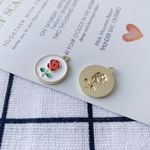 Dettaglio di ciondolo rosa smaltato e pendente dorato per orecchini fai da te