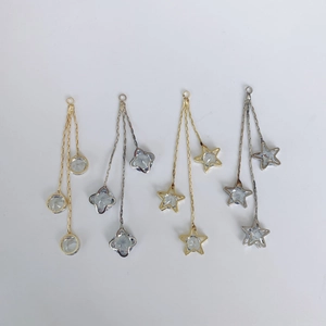 Detailed view of silver and gold star tassel pendants with sparkling rhinestone accents