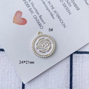 Vista dettagliata del ciondolo smaltato 24x21mm con perle e rilievo di rosa dorata