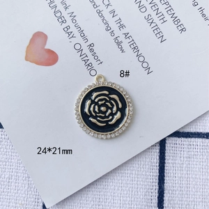 Dettaglio del ciondolo a rosa dorata 24x21mm con smalto nero e cristalli luccicanti