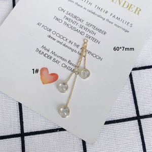 Detail of 60mm gold tassel earrings with three chains and sparkling round cubic zirconia