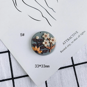 Detalle del colgante 3D de arcilla de 33mm con flores crema y girasol naranja