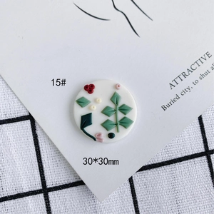 Detalle de dije de flor redondo de arcilla polimérica de 30mm con hojas y bayas