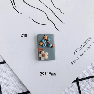 Detalle del colgante de flor de arcilla gris de 29x19mm con flores 3D y bayas decorativas