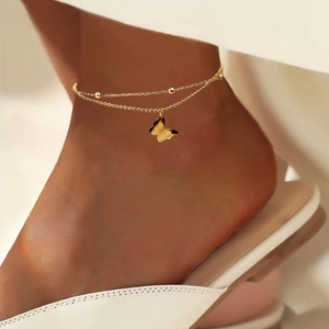 Detailansicht einer zweilagigen Fußkette mit Schmetterlingsanhänger und goldenen Perlen