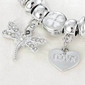 Detail of silver beaded bracelet with sparkling dragonfly, LOVE heart, and clover charms