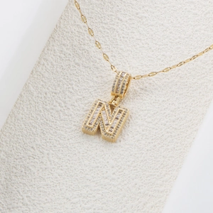 Dettaglio della collana con ciondolo lettera N dorata con zirconi cubici brillanti
