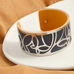 Silver hollow leaf cuff bracelet with reversible blue and orange leather lining