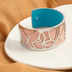 Detail of silver hollow butterfly cuff bracelet with pink and blue leather reversible texture