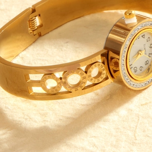 Golden bangle watch for women with rhinestone bezel and hollow Roman numeral link band