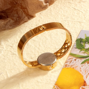 Golden stainless steel bangle watch with open circle design and crystal-set round dial