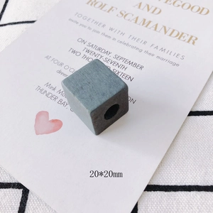 Close-up of 20x20mm grey-blue wooden cube bead with visible natural wood grain texture