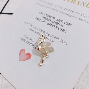 Detailansicht einer goldenen Flamingo-Brosche mit Flügeln aus weißem Perlmutt