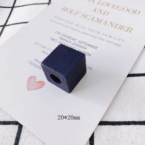 Detail view of a 20mm dark blue square wooden bead with a hole for DIY jewelry making