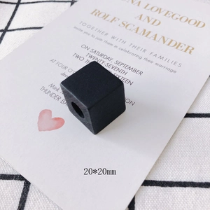 Detailed view of 20mm matte black square wood beads with center holes for DIY jewelry
