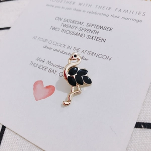 Detail eines eleganten Flamingo-Anhängers aus schwarzer Emaille auf Geschenkkarten