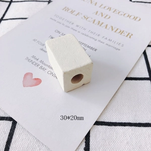 Close-up of a white rectangular wood bead with matte finish, measuring 30x20mm for DIY crafts