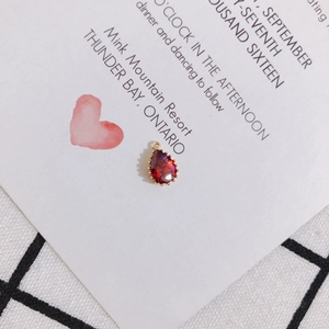 Close-up of a drop-shaped red zircon pendant with a gold-plated setting for DIY jewelry