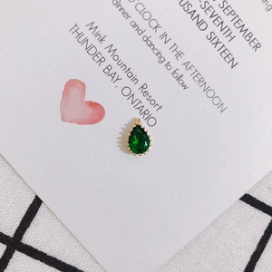 Macro view of teardrop green zircon pendant with gold frame for DIY jewelry making
