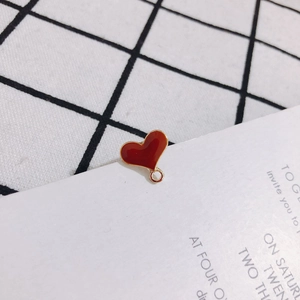 Detail of red enamel heart-shaped charm with gold metal trim and ring for DIY jewelry making