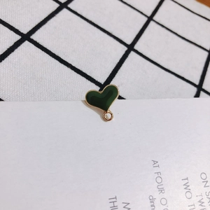 Detail of dark green heart enamel charm with gold-plated metal loop for DIY jewelry