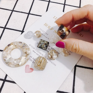 DIY mode-sieradenaccessoires van hars met geometrische ringen, goudfolie en schelpinlays