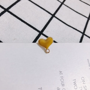 Close-up of heart-shaped yellow enamel pendant with gold-plated DIY jewelry ring