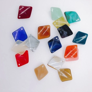 Macro detail of various colorful marbled acrylic diamond charms with holes for DIY jewelry