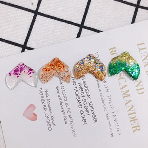 Macro shot of colorful resin mermaid tail charms with sparkling glitter for DIY jewelry making