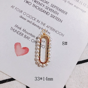 Detail of handmade oval pendant with gold wire wrap and white pearls for DIY jewelry