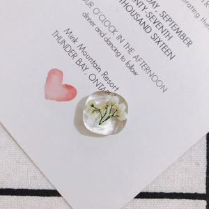 Makroaufnahme von Harzanhänger mit echten weißen Trockenblumen für DIY-Schmuckherstellung