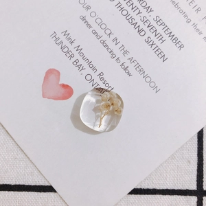 Makroaufnahme eines quadratischen Harzanhängers mit echten getrockneten Blumen für DIY-Schmuck