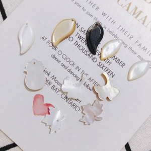 Makroaufnahme verschiedener Perlmutt-Anhänger in Blatt- und Herzform für DIY-Schmuck