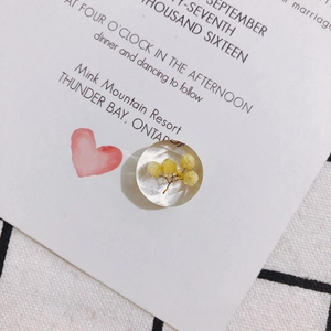 Macro detail of multifaceted resin charm with yellow dried flowers for DIY jewelry