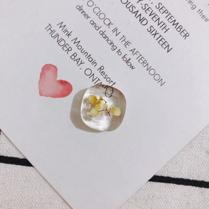Detail eines quadratischen Harzanhängers mit echten gelben Trockenblumen für DIY-Schmuck