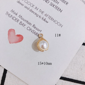 Detail eines weißen Perlenanhängers mit goldenem Texturrand und Aufhängeloch für DIY