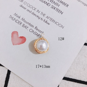 Nahaufnahme eines 17x13mm Perlenanhängers mit goldener Drahtumwicklung im Nest-Design