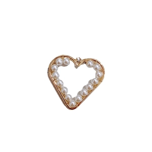 Handcrafted heart pendant with gold copper wire wrapping and white pearls on white background