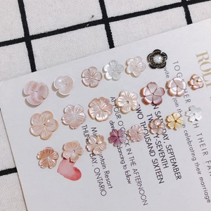 Macro detail of delicate flower-shaped mother-of-pearl charms for DIY jewelry making
