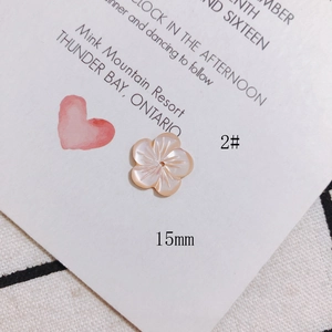 Macro shot of 15mm pink shell petal charm for DIY jewelry on white decorative card