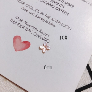 Macro shot of 6mm cross flower shaped natural shell bead with iridescent luster finish